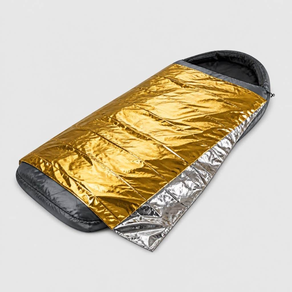 Couverture de survie posée sur un sac de couchage de nuit
